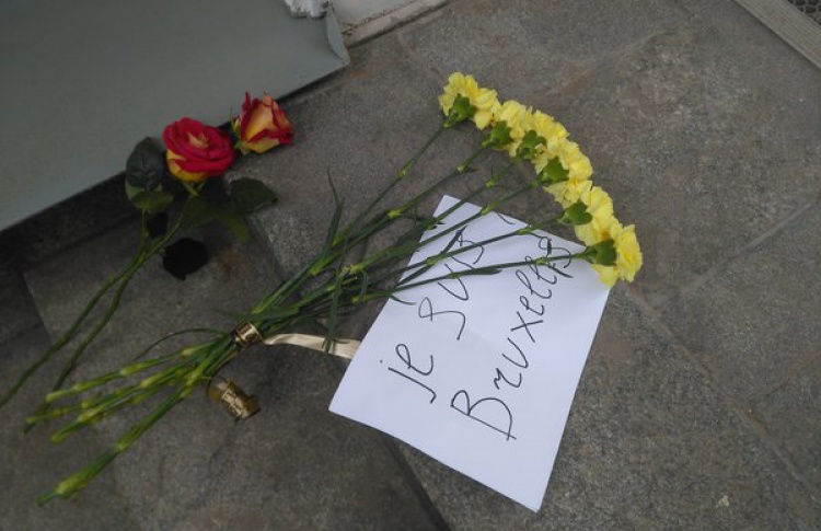 Люди несут цветы к зданию посольства Бельгии возле Арбата